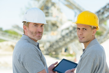 two engineers checking tablet outdoors