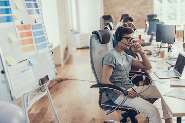 Concentrated guy in glasses is working in the call center