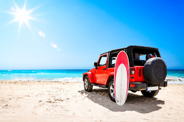 Summer red car on beach and sea landscape with blue sky and sun .