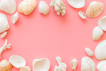 Summer at the sea design for blog with shells frame on pink background top view copy space