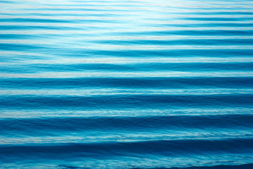 Water waves texture. Beautiful lake minimalist landscape,. Blue waves, horizon lines on water. Place for text © Smartha