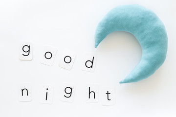 Good night text and moon for sleep concept on white background top view
