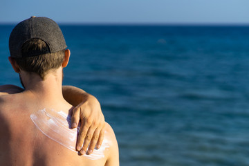 young man with wave-formed suncream on his shoulder