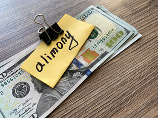 Payments alimony. Pile Dollars with sign alimony and money. Divorce and separation concept.