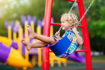 Child on playground. swing Kids play outdoor. - obrazy, fototapety, plakaty