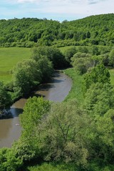 Fototapeta na wymiar Aerial view of peacefully flowing slow river arm surrounded by trees and meadows. Location recreational area Motova near Zvolen, central Slovakia