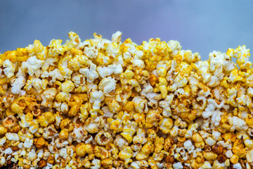Golden caramel popcorn closeup. Background of popcorn. Snacks and food for a movie.