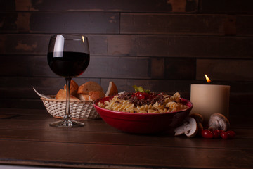 A suggestive dinner in the light of the candles, with pasta and red wine