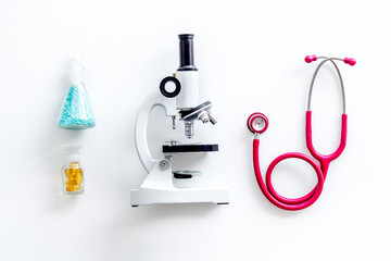 Desk of doctor in laboratory with microscope, stethoscope, test tube for research on white background top view