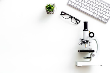Medical research with microscope, keyboard, glasses on white background top view space for text