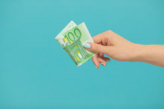 Female hands holding euro banknotes on a blue background.