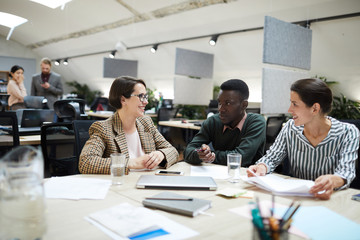 Multi-ethnic group of smiling business people working together in office, copy space