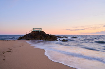 View point or gazebo over the rocks on a beach in Vila do Conde, Portugal, at sunset.