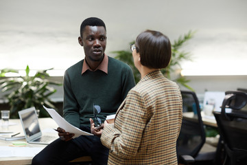 : Portrait of African-American man talking to female manager while working in office, copy space