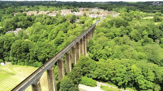 Pontcysyllte Aqueduct arch bridge canal waterway crossing. High aerial orbit across Welsh landscape valley.