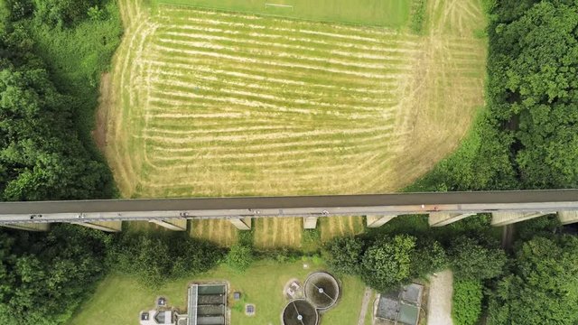Pontcysyllte Aqueduct arch bridge canal waterway crossing. Top down pull back tilt up aerial revealing the countryside surroundings.
