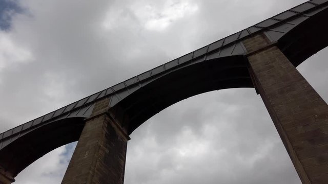 Pontcysyllte Aqueduct arch bridge canal waterway crossing. Slow dolly looking up at stone structure.
