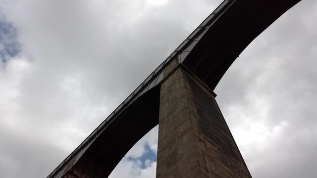Pontcysyllte Aqueduct arch bridge canal waterway crossing. Low angle slow dolly under arches.