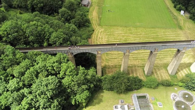 Pontcysyllte Aqueduct arch bridge canal waterway crossing. Slow ascending aerial view.