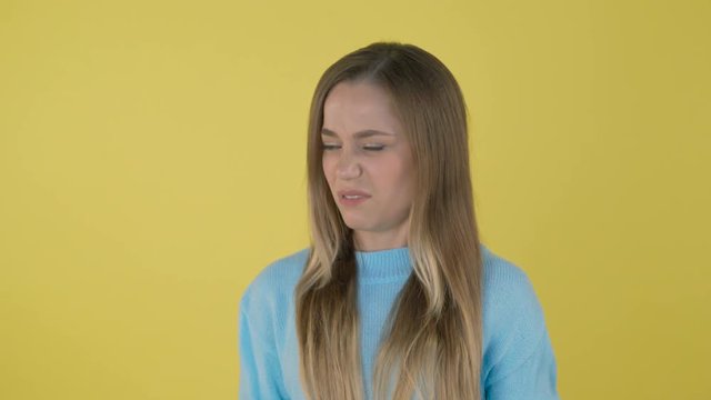 Young beautiful blonde elegant woman over isolated background smelling something stinky and disgusting, intolerable smell, holding breath with fingers on nose. Bad smells concept. 4K