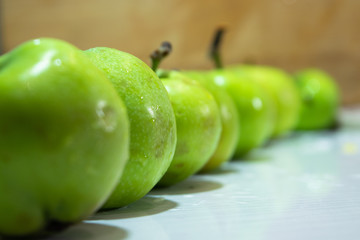 Green apples in a row on a white background.
