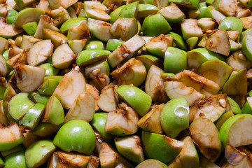 Sliced ​​green apples into small pieces, background and texture.