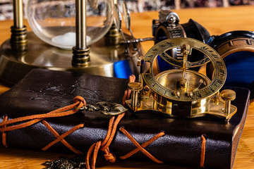 An Antique Brass Nautical Compass and Sundial, with a leather journal, goggles and a brass...