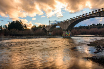 Kansas bridge in Trevelin, Chubut over the river against colorful sky