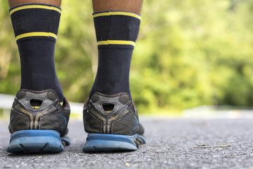 Man runner feet on road in Park workout wellness soft focus and focus close up on shoe