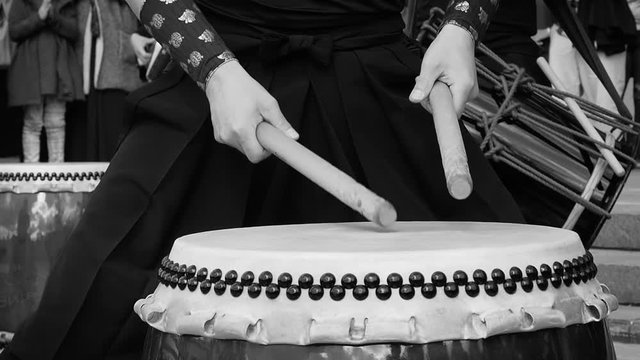 Musicians drummers play taiko drums chu-daiko outdoors. Culture folk music of Asia Korea, Japan, China. In black and white toning