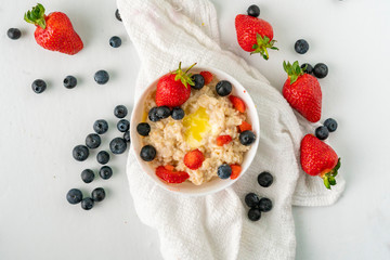 healthy breakfast with oatmeal porridge with starwberry and blueberry in a bowls