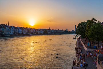 Top view from Middle Bridge of people relax and chill out on riverside, and swim and float on Rhine...