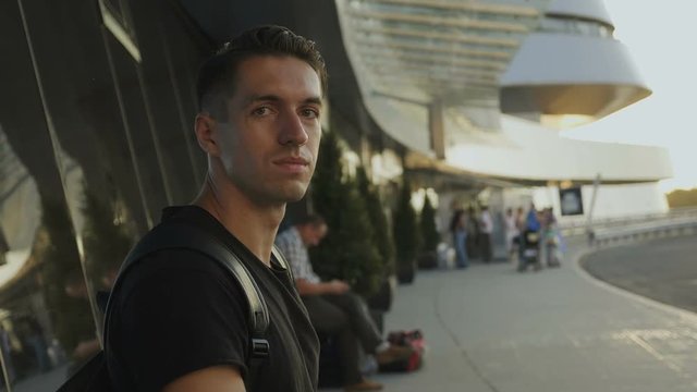 portrait of young male at airport, bus station or train station.