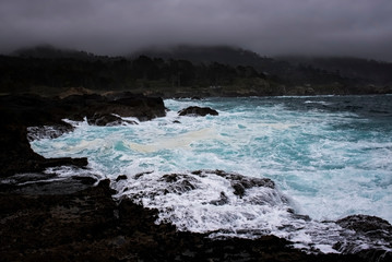 Blue Water in Stormy Surge against Rocky Shore in California