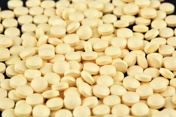 Close-up photo of many yellow pills. Medicine