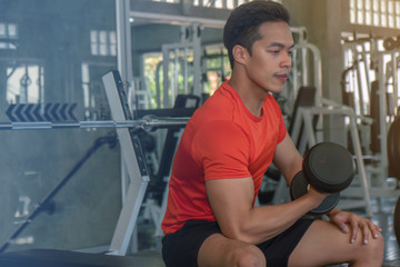 male having exercise lifting dumbbell in gym