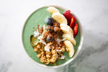 Spirulina yogurt with fruit in wooden bowl