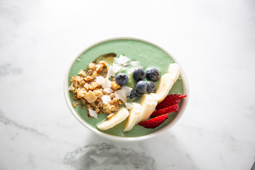 Spirulina yogurt with fruit in wooden bowl
