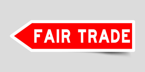 Arrow shape red color sticker in word fair trade on gray background