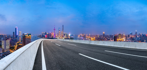 Shanghai skyline panoramic view with asphalt highway at night,China