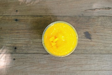 Refreshing Mango smoothie on wooden table, top view.