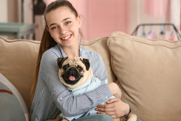 Teenage girl with cute pug dog at home
