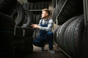 Fototapeta na wymiar Male seller in car tire store