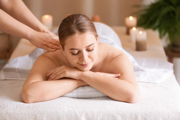 Obraz na płótnie Canvas Beautiful young woman receiving massage in spa salon