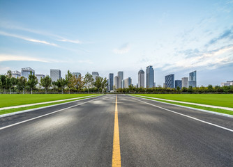 Fototapeta premium city road through modern buildings under blue sky