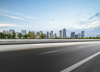 Obraz premium blurry empty asphalt road and modern buildings in the city