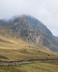 Volcano mountain peak on cloudy day with dirt road