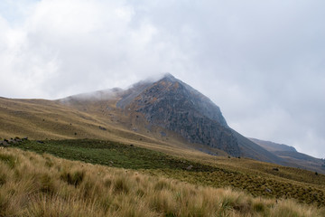 Volcano mountain peak on cloudy day with dirt road