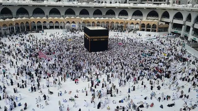 Muslim pilgrim umrah or hajj revolving circling tawaf around holy Kaaba inside masjidil haram mecca saudi arabia
