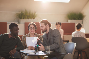 Warm toned portrait of group of people working in cafe, copy space